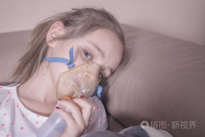 这个小女孩在家里吸气.这女孩病了,正在接受吸入治疗.照片-正版商用图