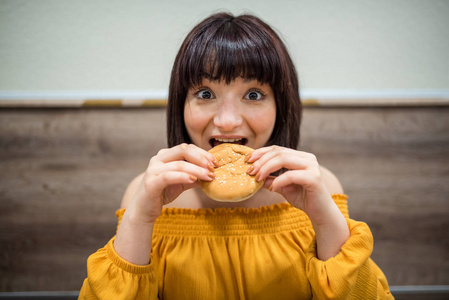 可爱的女孩坐在一家有快餐的咖啡馆里