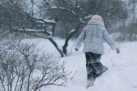 冬天森林里可爱的小女孩。下雪