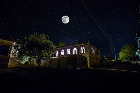 秋夜背景墙夜晚有云彩和星星的老式乡村别墅.寒冷的秋夜照片