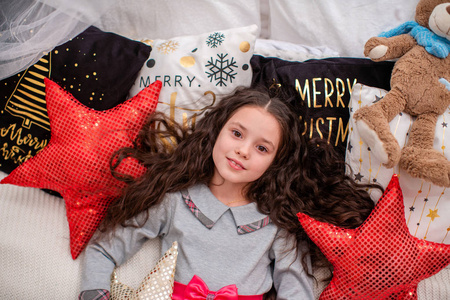 portrait of a child on New years eve, lying on the bed smiling 