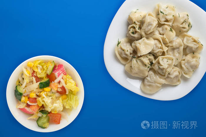  dumplings on a white plate on a colored background. Top view of