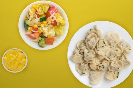  dumplings on a white plate on a colored background. Top view of