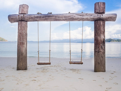 木质秋千,白色沙滩海景背景,假期或退休后旅行计划照片