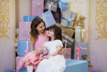 穿粉色连衣裙的漂亮女学生拥抱在一起,还有一位身着白色连衣裙的女孩