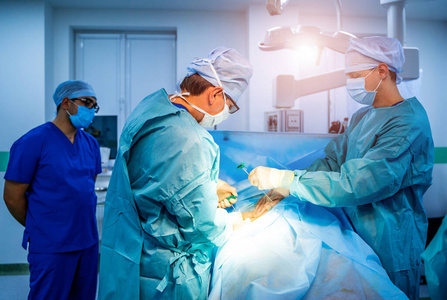 脊柱手术。手术室里带着手术设备的一群外科医生。现代医学背景