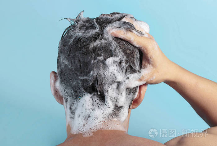 男性用洗发水和泡沫在蓝色背景上洗手后视图