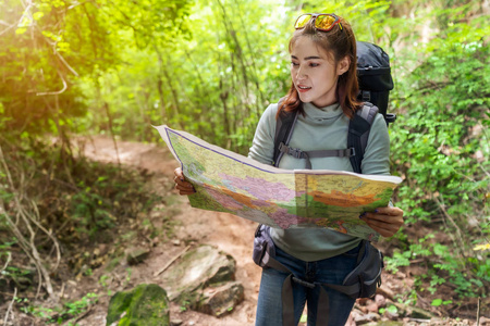 背着背包和地图的女旅行者在