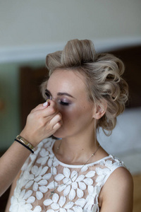 Young beautiful girl blonde bride in a sexy white boudoir dress 