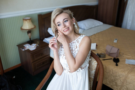 Young beautiful girl blonde bride in a sexy white boudoir dress 