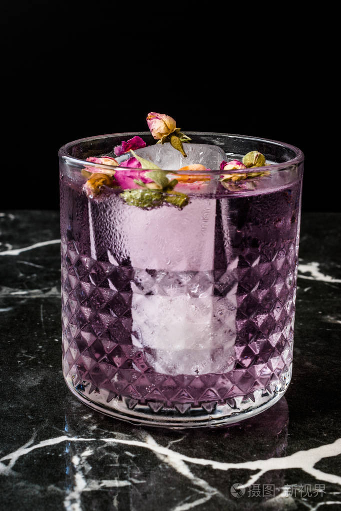 粉红色杜松子酒鸡尾酒有干玫瑰花蕾和冰块