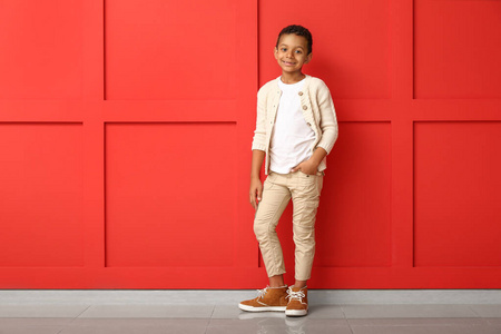 时尚的非洲裔美国男孩，穿着秋装，在彩色墙上