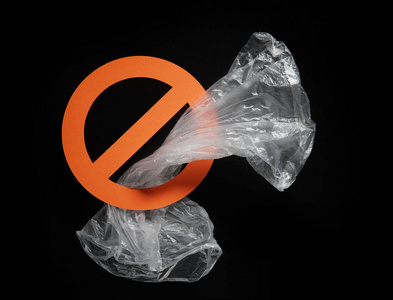 Empty plastic bag in a stop sign on black background. Concept of