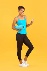 运动型非裔美国人，彩色背景为瑜伽垫和手机