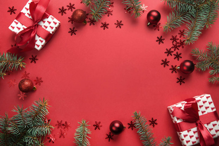圣诞相框，红色背景上有礼物球冷杉树。贺卡。新年快乐。文本空间
