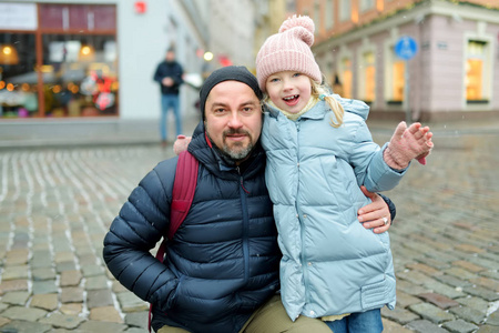 拉脱维亚里加，年轻的父亲和他的女儿在冬日玩得很开心