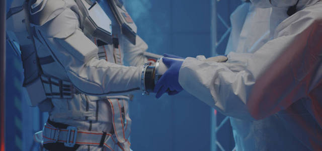 帮助宇航员戴手套的科学家