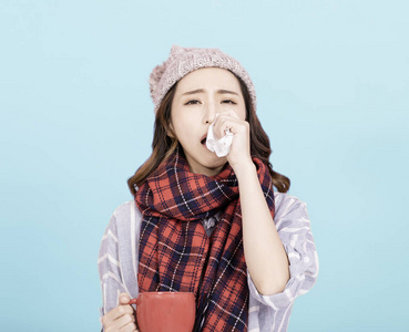 sick young woman blowing her nose 