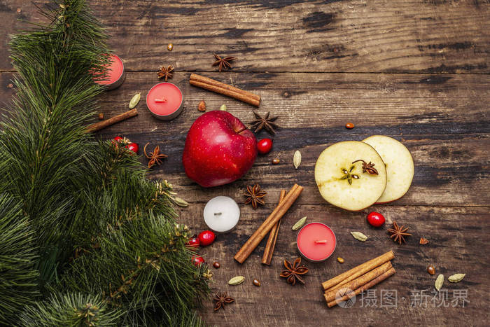 精神圣诞背景。新年树，新鲜苹果，肉桂，狗玫瑰，蜡烛，小豆蔻，八角茴香。自然装饰，复古木板