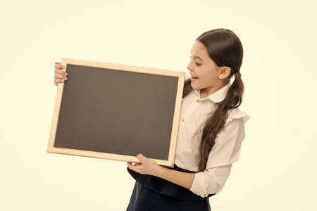 这节课的开始。一个拿着空白黑板上私人课的小女生。小学生在学校上学习课。在黑板上，一个可爱的孩子背诵课文