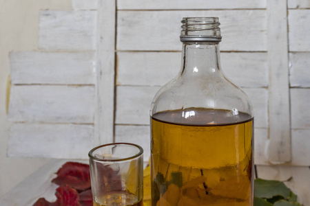 秋叶背景上的白兰地酒瓶和酒杯
