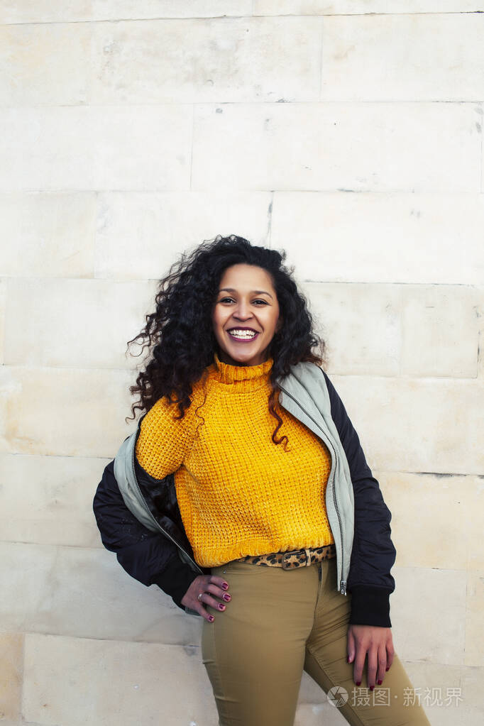 年轻漂亮的美国女孩快乐的微笑在城市背景下,生活方式的人在外面