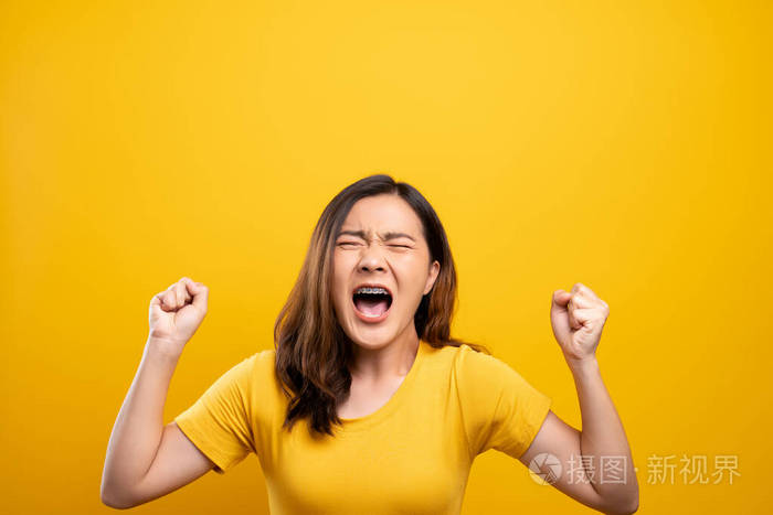 愤怒的女人在黄色背景下尖叫