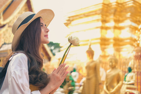 woman traveler tourist praying at buddhist temple. journey trip 