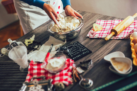 Young pretty woman prepares the dough and bakes gingerbread and 