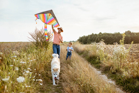 父子俩在田野上牵着风筝散步