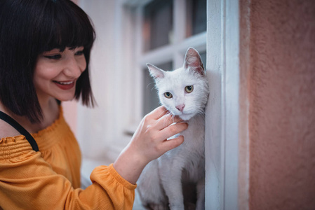 可爱的女孩喜欢一只白色的流浪猫