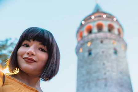 Beautiful woman takes selfie in front of Galata tower 