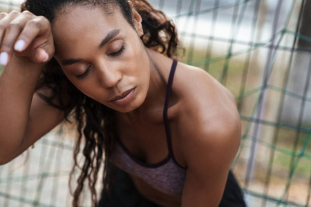 Image closeup of african american woman standing by metal fence 