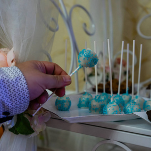 Male hand taking a colorful lollipop from a wedding candy bar. 