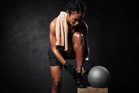 美国黑人妇女用健身球系鞋带的照片