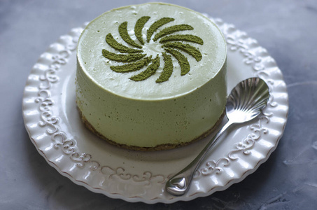 Cheesecake without baking with matcha tea on a white plate  