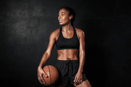 身着运动服手持篮球微笑的非洲裔美国妇女形象