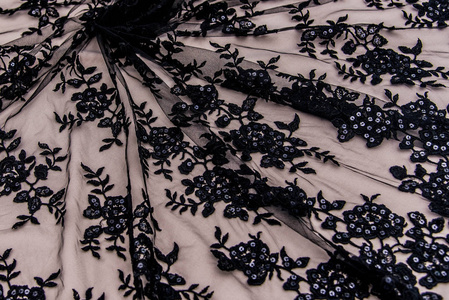 纹理蕾丝面料。白底花边工作室。纱或线制成的薄织物。象牙色蕾丝布的背景图像。米色背景的黑色蕾丝。