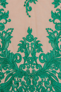 纹理蕾丝面料。白底花边工作室。纱或线制成的薄织物。象牙色蕾丝布的背景图像。米黄色背景上的绿色蕾丝。
