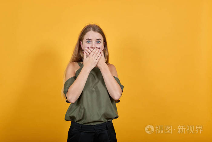 年轻的金发女子惊讶的表情用手捂住嘴