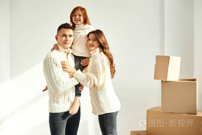一家人在白色背景的新家里打开纸箱