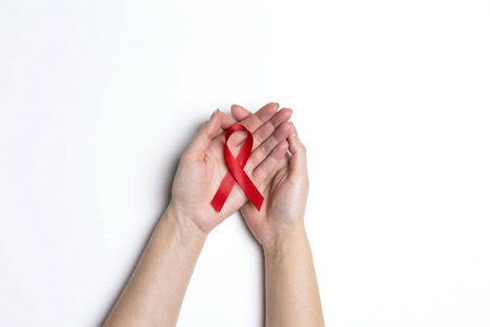 白色背景上的女性手上的红色艾滋病丝带意识。