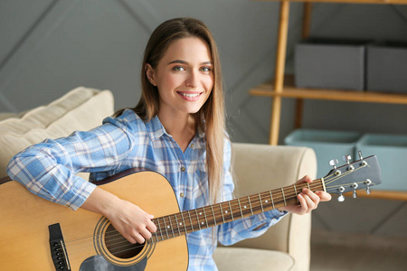 年轻女子在家弹吉他