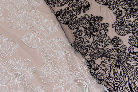 纹理蕾丝面料。白底花边工作室。纱或线制成的薄织物。象牙色蕾丝布的背景图像。背景为米色和白色蕾丝。