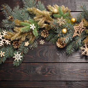 fir branches with Christmas decor on old dark wooden background 