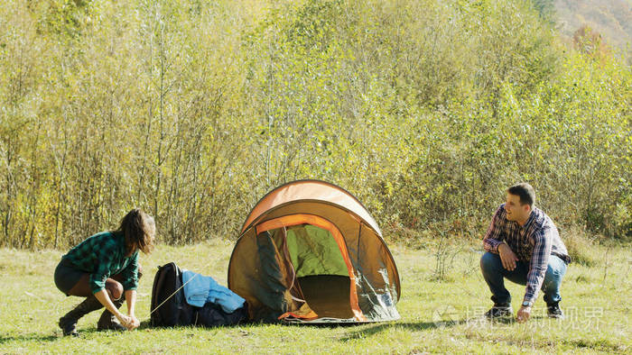 漂亮的妻子帮丈夫搭帐篷
