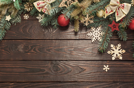 fir branches with Christmas decor on old dark wooden background 