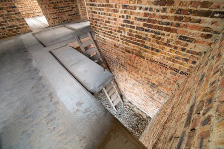 Interior of unfinished brick house with concrete floor and bare 