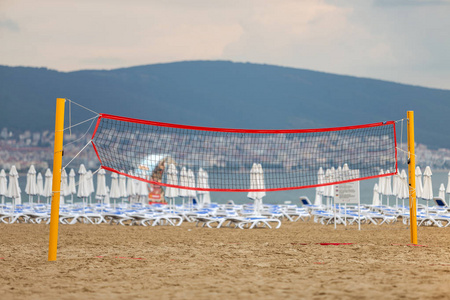 Empty volleyball net on a sandy beach on the sea shore in summer