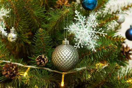 美丽的绿色圣诞树，装饰着球和花环。特写照片